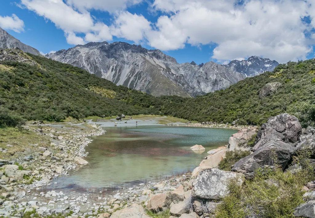 Blue Lake med grønt vand og grå bjerge i Aoraki/Mount Cook National Park på New Zealand