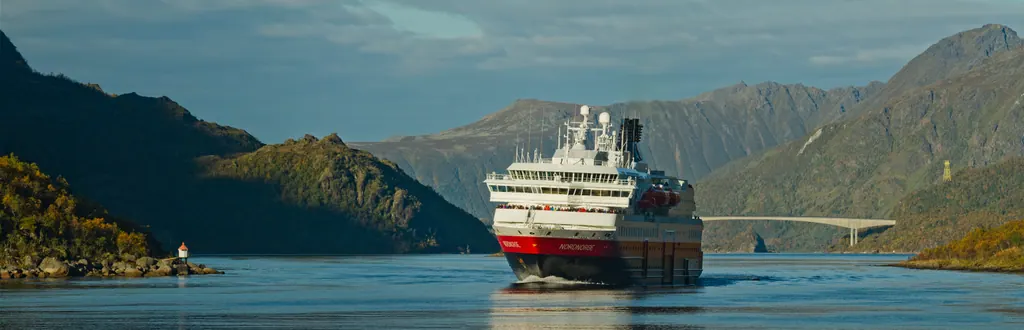 Hurtigrutens skib MS Nordnorge i det smalle Raftsundet ved Lofoten i gyldent septemberlys