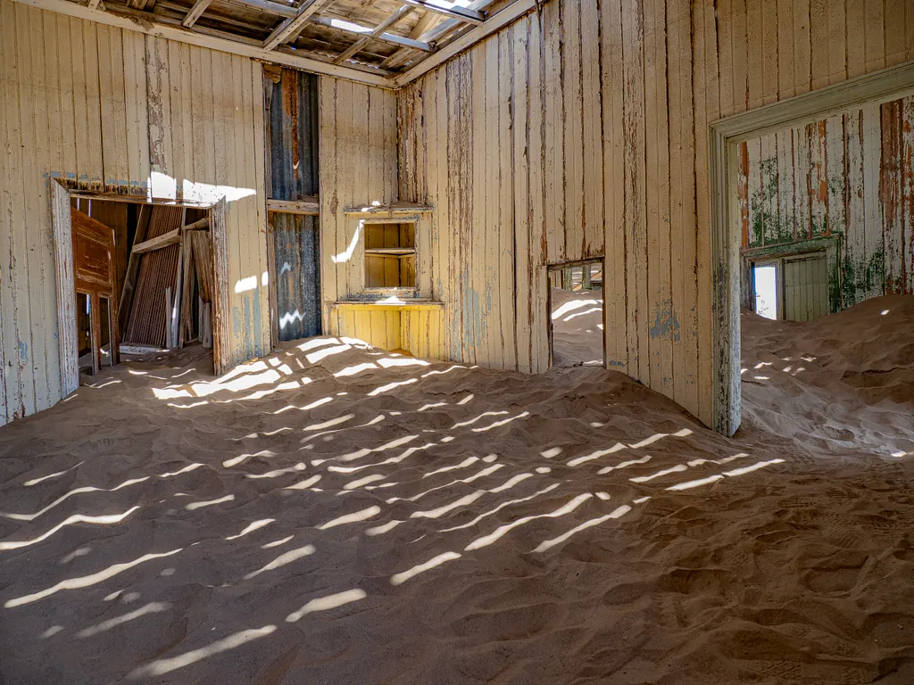 Sand har fyldt rummene i et forladt hus i Kolmanskop