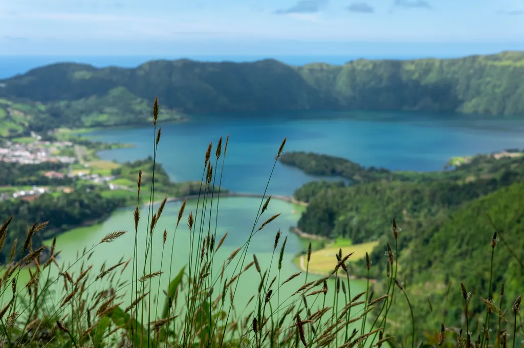 Den blå og den grønne kratersø i Sete Cidades på São Miguel, omgivet af grønne kraterskrænter og landsbyen ved bredden