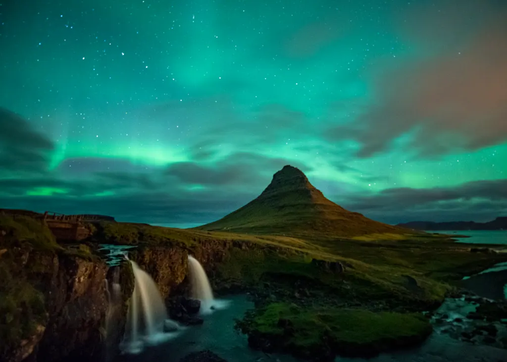 Nordlys over bjerget Kirkjufell og to vandfald på Snæfellsnes i Island