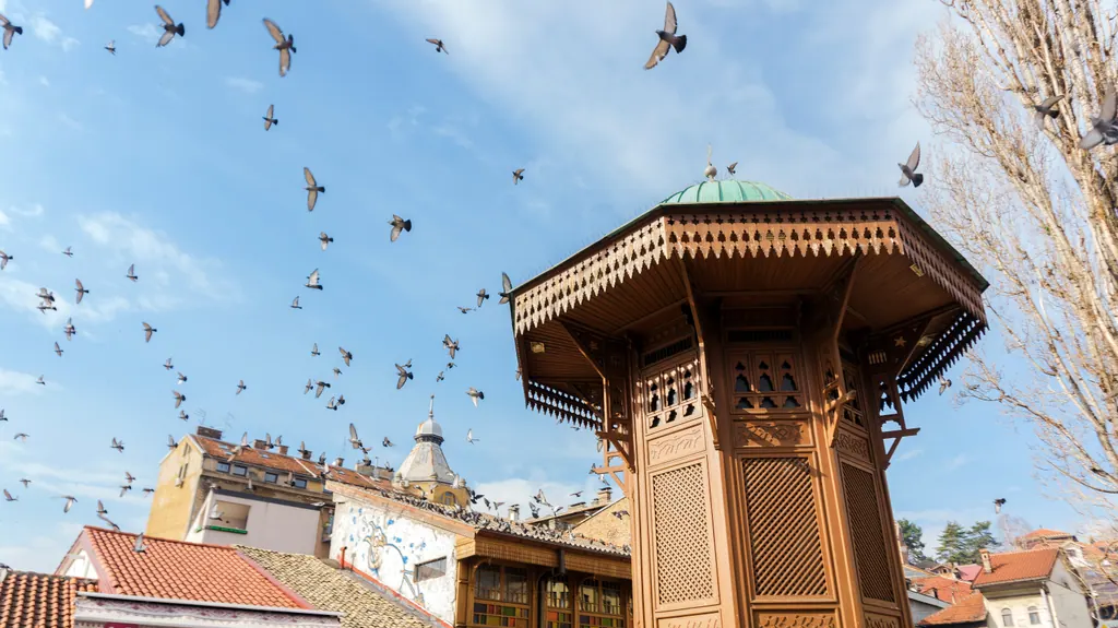 Brønden Sebilj i Baščaršija i Sarajevo med duer på en blå himmel