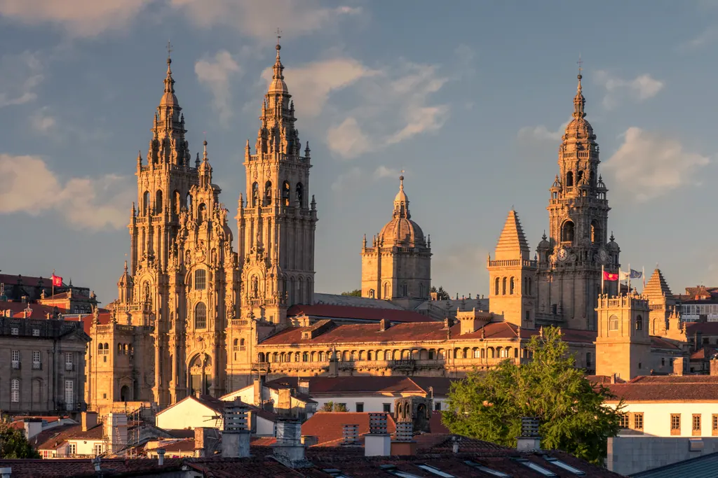 Katedralen i Santiago de Compostela med tårnene i gyldent aftenlys over byens tage