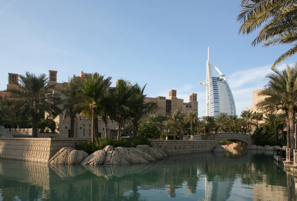 Burj Al Arab med sin sejlformede silhuet bag palmer og kanalerne ved Madinat Jumeirah i Dubai