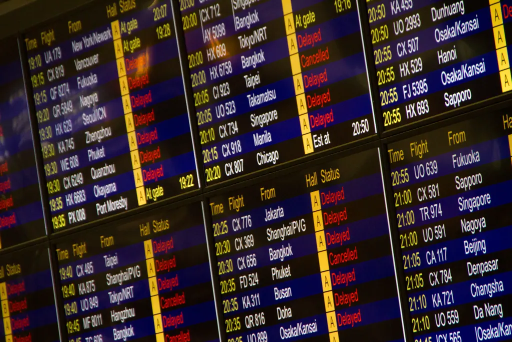 Informationstavle i en lufthavn, hvor mange fly står som forsinkede og aflyste med rød skrift