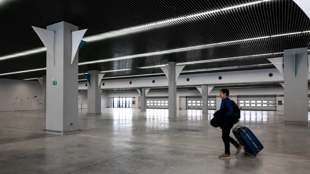 Rejsende med kuffert på vej gennem en stor, lys lufthavnshal